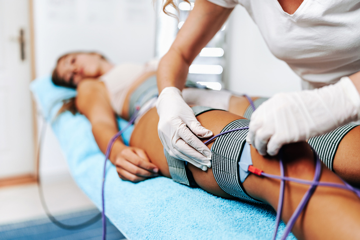 Elektrotherapie am Bein mit Elektroden in physiotherapeutischer Behandlung